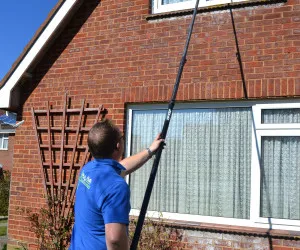 David Roberts washing upstairs windows with extendable wash brush