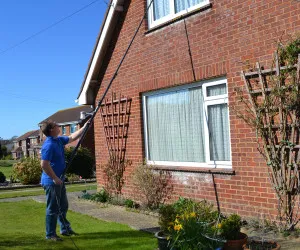 David Roberts washing upstairs windows with extendable wash brush
